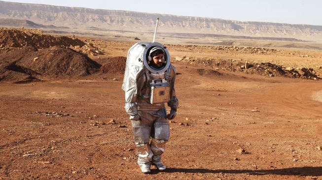 Seorang astronot dari tim Eropa dan Israel berjalan dengan pakaian luar angkasa selama misi pelatihan untuk planet Mars di sebuah situs yang mensimulasikan stasiun di luar lokasi di Kawah Ramon, Mitzpe Ramon, Gurun Negev, Israel, pada (10/10/2021). [JACK GUEZ / AFP]