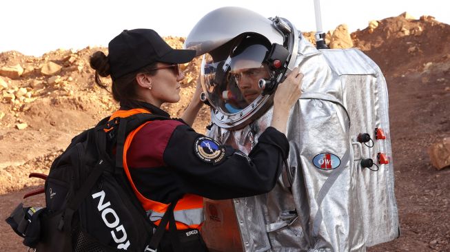 Teknisi membantu astronot dari tim Eropa dan Israel untuk mengenakan pakaian antariksa sebelum memulai misi pelatihan untuk planet Mars di sebuah situs yang mensimulasikan stasiun di luar lokasi di Kawah Ramon, Mitzpe Ramon, Gurun Negev, Israel, pada (10/10/2021). [JACK GUEZ / AFP]