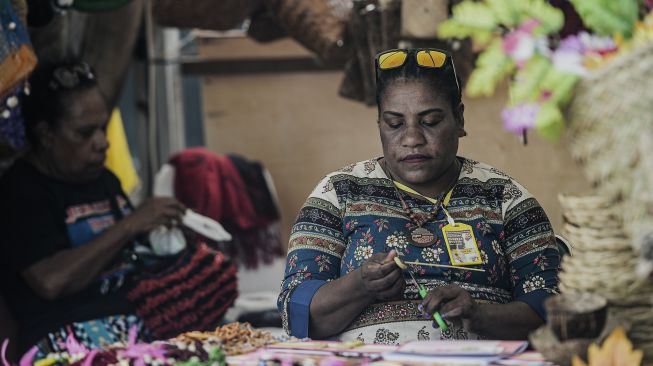 Mama-mama Papua membuat kerajinan tangan dari bahan daun kelapa di sebuah stan Pameran dan Pagelaran Budaya Nasional di Holtekamp Jayapura, Papua, Kamis (14/10/2021). [ANTARA FOTO/Indrayadi TH]