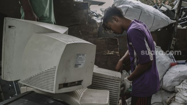 Pekerja menata limbah elektronik di tempat penampungan di Legok, Kabupaten Tangerang, Banten, Kamis (14/10/2021). [Suara.com/Hilal Rauda Fiqry]