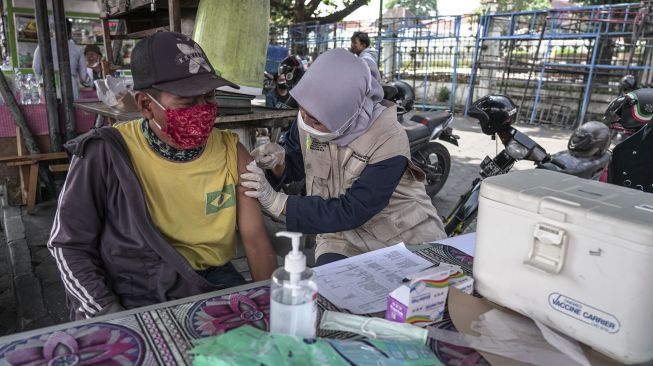 Pedagang menerima suntikan vaksin COVID-19 saat pelaksanaan vaksinasi jemput bola di kawasan Malioboro, Yogyakarta, Kamis (14/10/2021). [ANTARA FOTO/Hendra Nurdiyansyah]