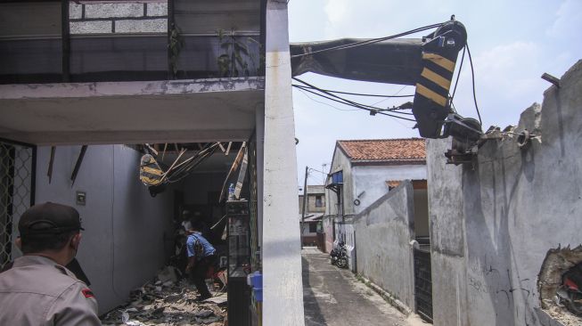 Sejumlah petugas melakukan evakuasi korban akibat alat berat crane yang jatuh menimpa rumah warga di Pancoran Mas, Depok, Jawa Barat, Jumat (15/10/2021).  ANTARA FOTO/Asprilla Dwi Adha