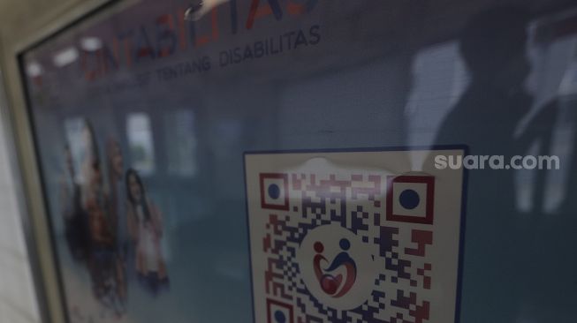 Tanda kampanye inklusif tentang disabilitas terpasang di salah satu gerbong kereta commuter line yang berhenti di Stasiun Jatinegara, Jakarta, Jumat (15/10/2021). [Suara.com/Angga Budhiyanto]