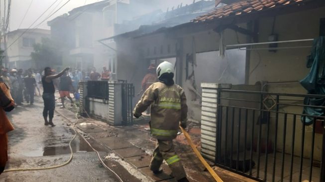 Petugas dan warga bahu-membahu memadamkan kebakaran rumah tinggal di Kembangan, Jakarta Barat, Jumat (15/10/2021). [Twitter@humasjakfire]