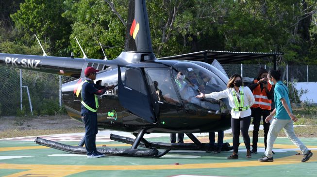 Petugas mengarahkan penumpang untuk menaiki helikopter yang dioperasikan operator Fly Bali Heli di Badung, Bali, Kamis (14/10/2021). ANTARA FOTO/Fikri Yusuf