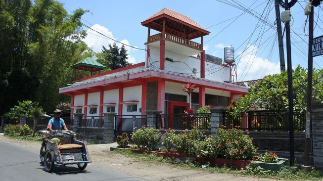 Seorang tukang becak melintas rumah produksi konten berita bohong dan informasi tidak benar (hoax) di Desa Grujugan Lor, Jambesari Darus Sholah, Bondowoso, Jawa Timur, Jumat (15/102021).  ANTARA FOTO/Seno