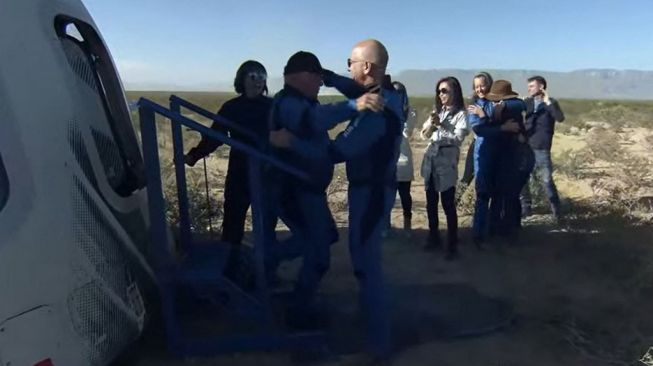 William Shatner dan Jeff Bezos usai perjalanan luar angkasa dengan Blue Origin, Rabu (13/10/2021). [Handout/Blue Origin/AFP]