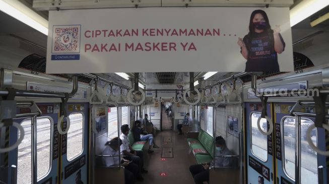 Sejumlah penumpang berada di dalam gerbong kereta commuter line yang dipasangi tanda kampanye inklusif tentang disabilitas yang berangkat dari Stasiun Jatinegara, Jakarta, Jumat (15/10/2021). [Suara.com/Angga Budhiyanto]