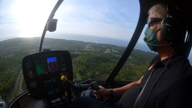 Seorang pilot menerbangkan helikopter yang dioperasikan operator Fly Bali Heli di Badung, Bali, Kamis (14/10/2021). ANTARA FOTO/Fikri Yusuf