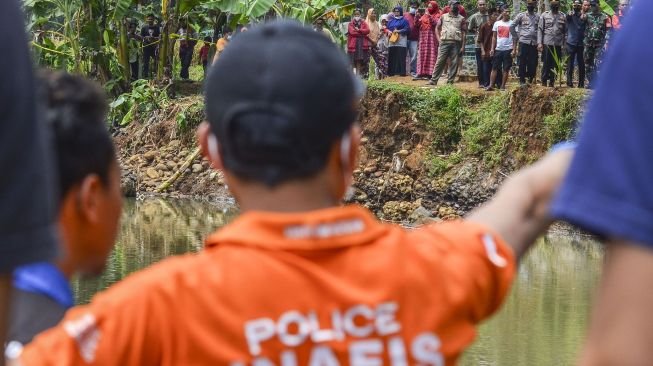 Petugas tim inafis melakukan olah tempat kejadian perkara siswa yang tewas tenggelam di Sungai Cileueur, Desa Utama, Kabupaten Ciamis, Jawa Barat, Sabtu (16/10/2021). ANTARA FOTO/Adeng Bustomi