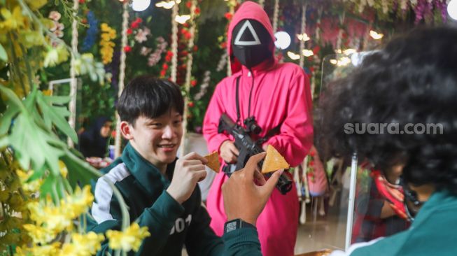 Pengunjung mengikuti permainan Squid Game di Strawberry Cafe, Jakarta Barat, Sabtu (16/10/2021). [Suara.com/Alfian Winanto]