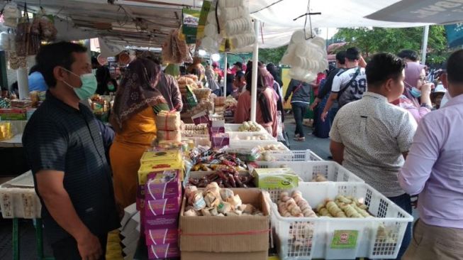 Pedagang oleh-oleh bakpia, Bejo saat melayani pembeli di sekitar Malioboro, Kota Jogja, Minggu (17/10/2021).[Muhammad Ilham Baktora / SuaraJogja.id]