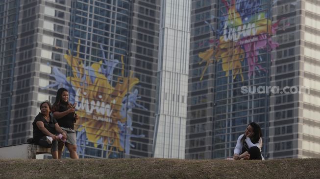 Warga berfoto di Hutan Kota GBK, Kompleks Gelora Bung Karno (GBK), Senayan, Jakarta, Minggu (17/10/2021). [Suara.com/Angga Budhiyanto]