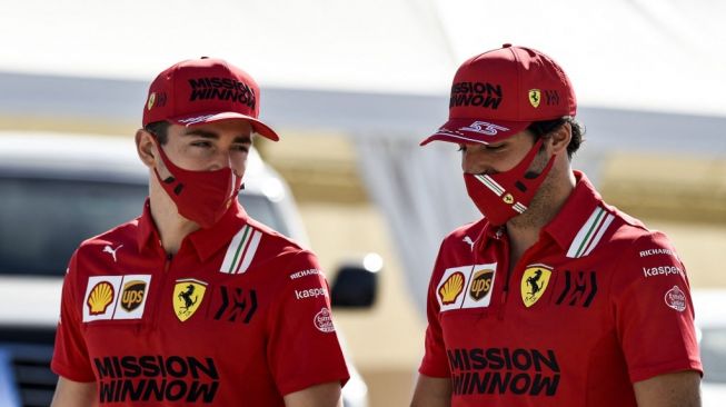 Driver F1 tim Scuderia Ferrari asal Monako, Charles Leclerc dan Carlos Sainz Jr., asal Spanyol, tiba di sirkuit sebelum dimulainya hari ketiga tes pramusim Formula One (F1) di Sirkuit Internasional Bahrain, Kota Sakhir 2021 [AFP/Mazen Mahdi]. 