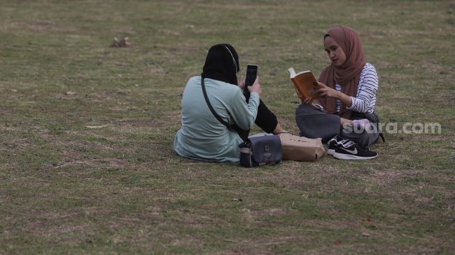 Warga berfoto di Hutan Kota GBK, Kompleks Gelora Bung Karno (GBK), Senayan, Jakarta, Minggu (17/10/2021). [Suara.com/Angga Budhiyanto]