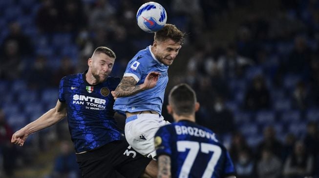 Bek Inter Milan Milan Skriniar (kiri) dan penyerang Lazio Ciro Immobile melakukan sundulan saat pertandingan sepak bola Serie A Italia antara Lazio dan Inter di stadion Olimpiade, Roma, pada (16/10/2021). [FILIPPO MONTEFORTE / AFP]