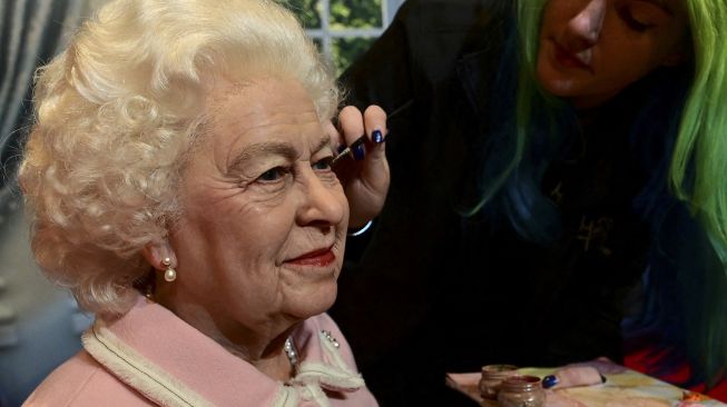 Seniman studio Emma Meehan memberikan sentuhan akhir pada patung lilin baru Ratu Elizabeth II Inggris di Madame Tussauds, Blackpool, Inggris, pada (14/10/2021). [PAUL ELLIS / AFP]