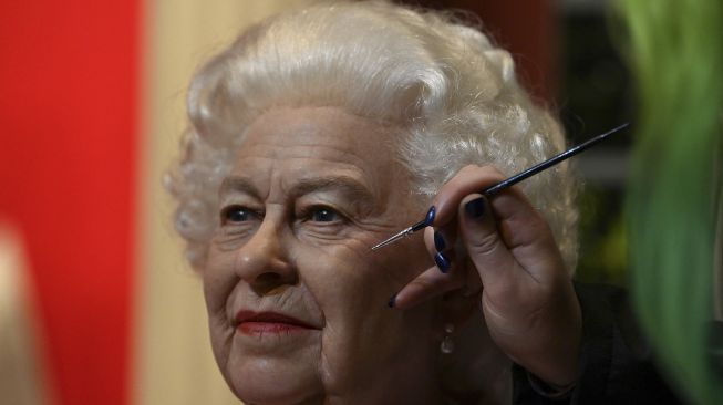 Seniman studio Emma Meehan memberikan sentuhan akhir pada patung lilin baru Ratu Elizabeth II Inggris di Madame Tussauds, Blackpool, Inggris, pada (14/10/2021). [PAUL ELLIS / AFP]