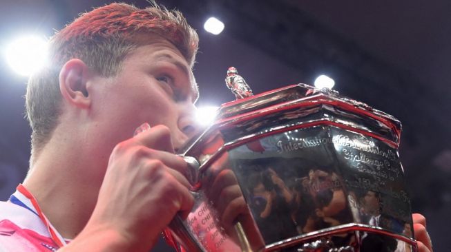 Victor Axelsen mencium trofi usai Denmark menjuarai Piala Thomas pada 2016 lalu. [JOHANNES EISELE / AFP]