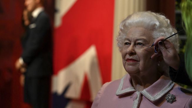 Seniman studio Emma Meehan memberikan sentuhan akhir pada patung lilin baru Ratu Elizabeth II Inggris di Madame Tussauds, Blackpool, Inggris, pada (14/10/2021). [PAUL ELLIS / AFP]