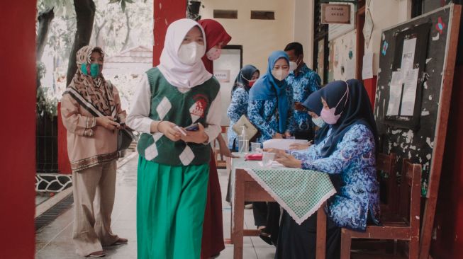 Sejumlah siswi sekolah dasar mendaftarkan dirinya sebelum diVaksinasi Covid-19 Pfizer di SDN Karawaci 5, Kota Tangerang, Banten, Senin 18/10. ( Suara.com/ Hilal Rauda Fiqry)

