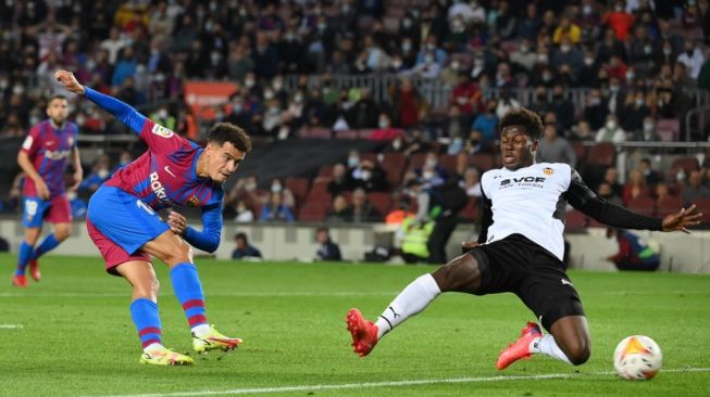 Aksi pemain pengganti Barcelona Philippe Coutinho saat mencetak gol ke gawang Valencia di laga lanjutan La Liga Spanyol di Stadion Camp Nou, Senin (18/10/2021) dini hari WIB. (foto: AFP)