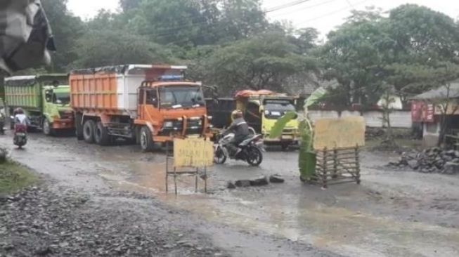 Jalan Rusak Parah, Warga Desa Cipinang Tancapkan Plang dan Pohon Pisang