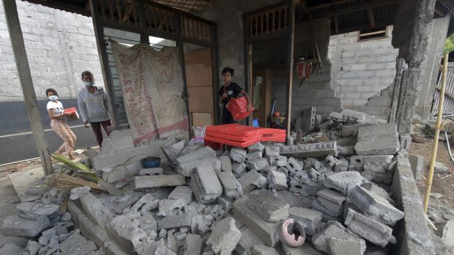 Warga melihat kondisi bangunan rumahnya yang rusak berat akibat gempa bumi di Banjar Dinas Temakung, Desa Ban, Karangasem, Bali, Senin (18/10/2021). [ANTARA FOTO/Nyoman Hendra Wibowo]