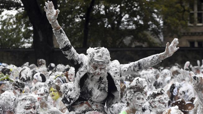 Mahasiswa tahun pertama di University of St Andrews berpartisipasi dalam pertarungan busa saat acara tahunan Raisin Monday di Lower College Lawn, St Andrews, Skotlandia, pada (18/10/2021). [ANDY BUCHANAN / AFP]