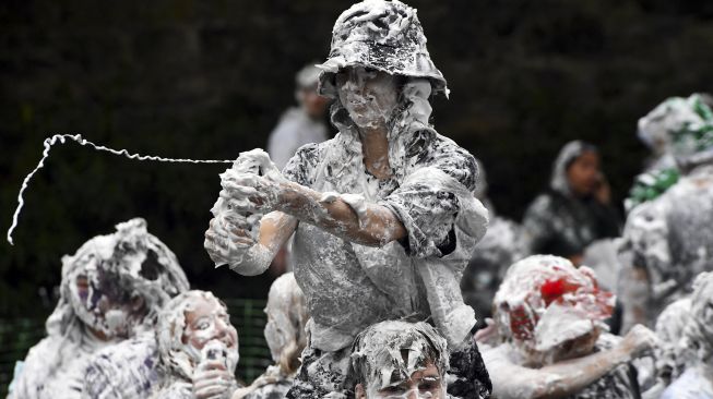 Mahasiswa tahun pertama di University of St Andrews berpartisipasi dalam pertarungan busa saat acara tahunan Raisin Monday di Lower College Lawn, St Andrews, Skotlandia, pada (18/10/2021). [ANDY BUCHANAN / AFP]