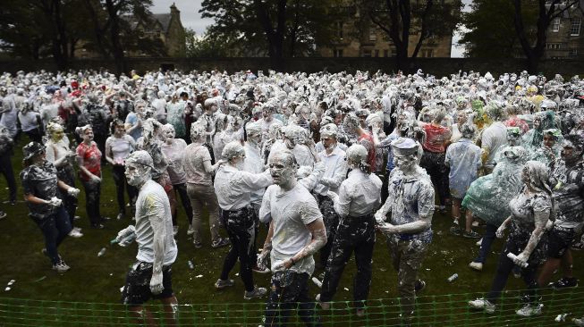 Mahasiswa tahun pertama di University of St Andrews berpartisipasi dalam pertarungan busa saat acara tahunan Raisin Monday di Lower College Lawn, St Andrews, Skotlandia, pada (18/10/2021). [ANDY BUCHANAN / AFP]