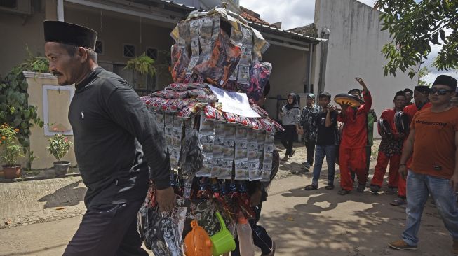 Sejumlah warga menggotong barang sedekah saat Perayaan Maulid Nabi Muhammad di Kampung Sukalila, Kelapa Dua, Serang, Banten, Selasa (19/10/2021). [ANTARA FOTO/Asep Fathulrahman]