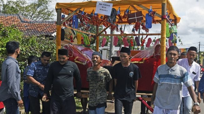 Sejumlah warga menggotong barang sedekah saat Perayaan Maulid Nabi Muhammad di Kampung Sukalila, Kelapa Dua, Serang, Banten, Selasa (19/10/2021). [ANTARA FOTO/Asep Fathulrahman]