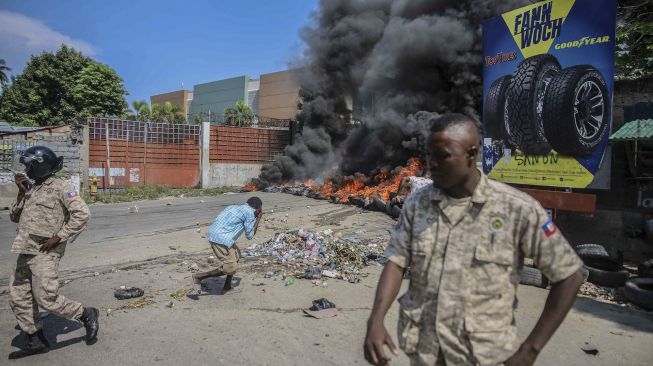 Ban terbakar menyusul seruan pemogokan umum oleh beberapa asosiasi profesional dan bisnis untuk mengecam ketidakamanan di Port-au-Prince, Haiti, pada (18/10/2021). [RICHARD PIERRIN / AFP]