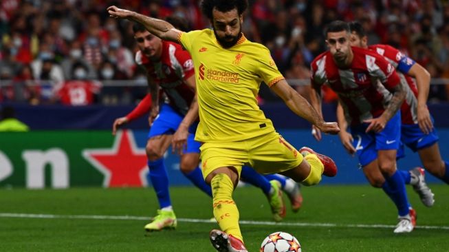 Aksi Mohamed Salah saat Liverpool mendapatkan hadiah penalti di laga lanjutan Liga Champions menghadapi tuan rumah Atletico Madrid di Wanda Metropolitano Stadium, Rabu (20/10/2021) dini hari WIB. The Reds menang 3-2. (foto: AFP)