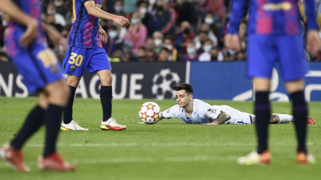 Gelandang Dynamo Kiev Mykola Shaparenko (tengah) terbaring di tanah selama pertandingan sepak bola Grup E Liga Champions UEFA antara FC Barcelona dan Dynamo Kiev di stadion Camp Nou, Barcelona, pada (20/10/2021). [JOSEP LAGO / AFP]