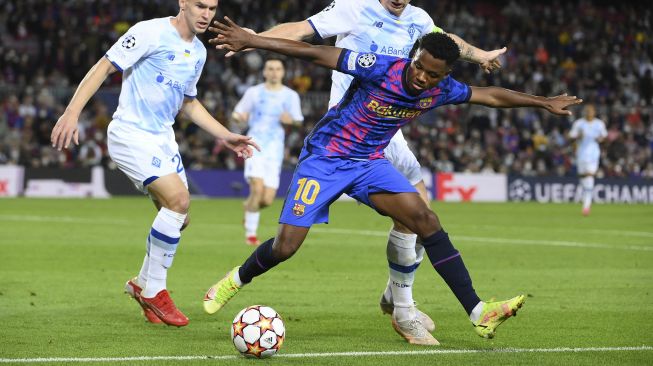 Gelandang Barcelona Ansu Fati berebut bola saat pertandingan sepak bola Grup E Liga Champions UEFA antara FC Barcelona dan Dynamo Kiev di stadion Camp Nou, Barcelona, pada (20/10/2021). [LLUIS GENE / AFP]