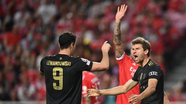 Reaksi Thomas Muller (kanan) dan Robert Lewandowski dalam matchday ketiga Grup E Liga Champions antara Benfica vs Bayern Munich di Estadio da Luz, Lisbon, Portugal, Kamis (21/10/2021) dini hari WIB. PATRICIA DE MELO MOREIRA / AFP.