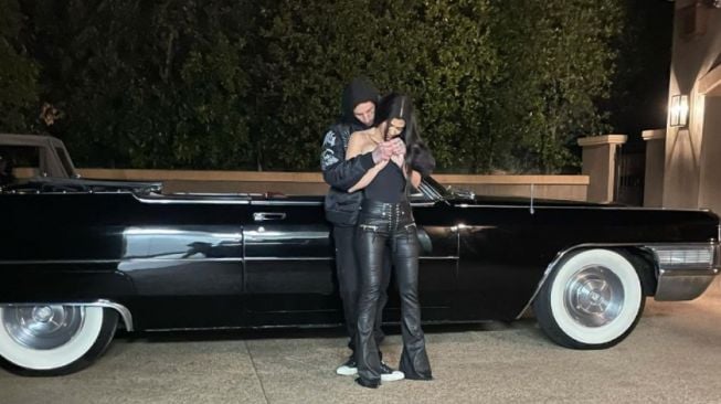 Travis Barker dan Kourtney Kardashian bersama mobil JJS (jalan-jalan santai), Cadillac DeVille Convertible 1965. Atapnya yang soft-top mudah dinaik-turunkan secara manual [Instagram: travisbarker].