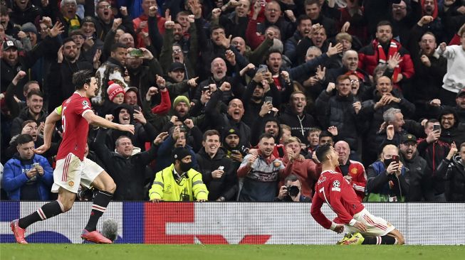 Striker Manchester United Cristiano Ronaldo merayakan gol ketiga timnya selama pertandingan sepak bola grup F Liga Champions antara Manchester United dan Atalanta di stadion Old Trafford, Manchester, Inggris, pada (20/10/2021). [PAUL ELLIS / AFP]