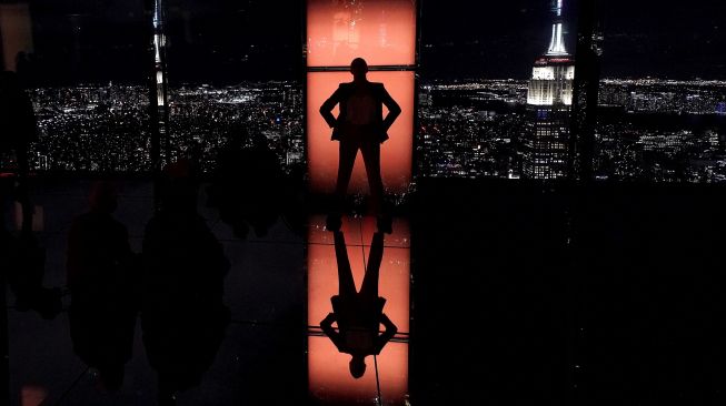 Influencer Rachel Wasley berpose di jendela saat anggota media menghadiri press preview untuk mengunjungi 'SUMMIT by Night' menjelang grand opening 'SUMMIT One Vanderbilt' di New York, pada (18/10/2021). [TIMOTHY A. CLARY / AFP]