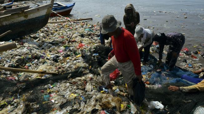 Nelayan beraktifitas di antara tumpukan sampah di pantai Sukaraja Bandar Lampung, Lampung, Jumat (22/10/2021).  ANTARA FOTO/Ardiansyah
