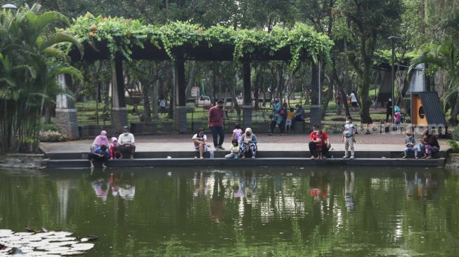 Sejumlah warga bersantai di Taman Spatodhea, Jakarta Selatan, Sabtu (23/10/2021). [Suara.com/Alfian Winanto]