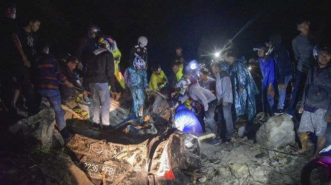 Warga berusaha mengevakuasi korban longsor yang selamat di kawasan tikungan PDAM Tirtanadi, Sibolangit,Deli Serdang, Sumatera Utara, Sabtu (23/10/2021) malam. [ANTARA FOTO/Fransisco Carolio]