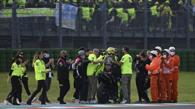 Pembalap Yamaha-SRT Italia Valentino Rossi (tengah) menemui penggemarnya setelah Grand Prix MotoGP Emilia-Romagna di Sirkuit Dunia Misano Marco-Simoncelli, Misano Adriatico, Italia, pada (24/10/2021). [ANDREAS SOLARO / AFP]