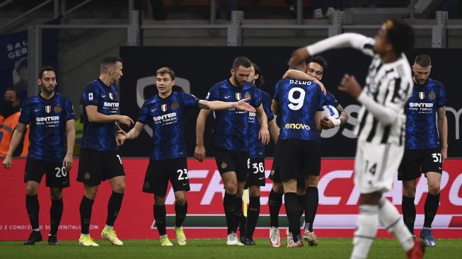 Para pemain Inter merayakan pembukaan skor selama pertandingan sepak bola Serie A Italia antara Inter dan Juventus di stadion Giuseppe-Meazza (San Siro), Milan, pada (24/10/2021). [MARCO BERTORELLO / AFP]