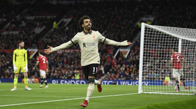 Gelandang Liverpool Mohamed Salah merayakan gol kelima mereka selama pertandingan sepak bola Liga Premier Inggris antara Manchester United dan Liverpool di Old Trafford, Manchester, Inggris, Minggu (24/10/2021). [OLI SCARFF / AFP]