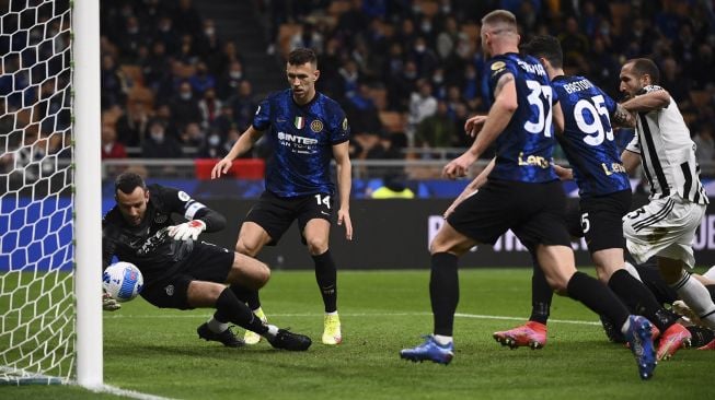 Penjaga gawang Inter Milan Samir Handanovic (kiri) meraih bola selama pertandingan sepak bola Serie A Italia antara Inter dan Juventus di stadion Giuseppe-Meazza (San Siro), Milan, pada (24/10/2021). [MARCO BERTORELLO / AFP]