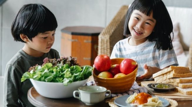 Ilustrasi anak makan sayur dan buah. (Pexels)