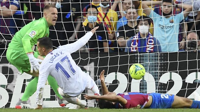 Pemain depan Real Madrid Lucas Vazquez mencetak gol kedua timnya selama pertandingan sepak bola Liga Spanyol antara FC Barcelona dan Real Madrid CF di stadion Camp Nou, Barcelona, Minggu (24/10/2021). [JOSEP LAGO / AFP]